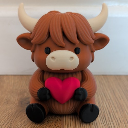 Highland cow figurine holding - cow,